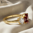 Side profile of a round brilliant lab-created ruby trilogy engagement ring in 18kt yellow gold with round brilliant lab-grown diamond side stones and a four claw basket setting.