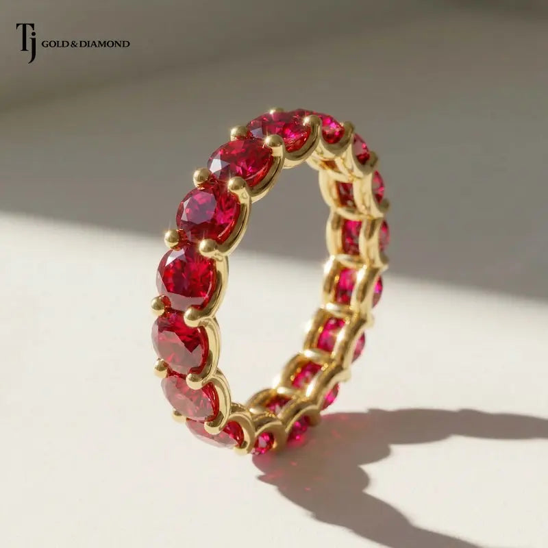 Full eternity ring featuring round brilliant lab-created rubies in 18kt yellow gold.