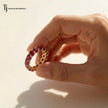 Created ruby full eternity ring in 18kt yellow gold held in hand with round brilliant lab-created rubies.