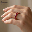 Created ruby full eternity ring in 18kt yellow gold worn on hand with round brilliant lab-created rubies.