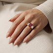 Emerald cut lab-created ruby trilogy engagement ring in 18kt yellow gold with emerald cut lab-grown diamond side stones worn on hand
