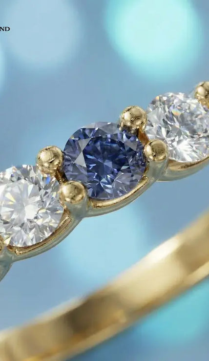 Close-up of an Alternating Created Sapphire & Lab-Grown Diamond Half Eternity Ring in 18kt Yellow Gold featuring round blue sapphires and brilliant diamonds.