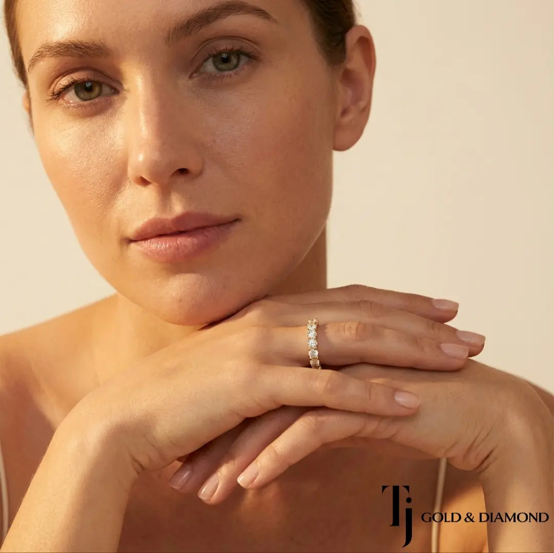 Model wearing Shared Prong Half Eternity diamond wedding band in 18kt yellow gold, close-up lifestyle shot