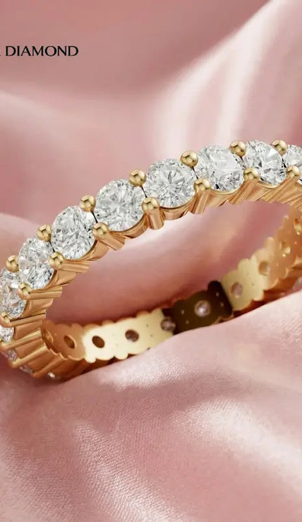 Shared prong setting full eternity diamond wedding band in 18kt yellow gold with round brilliant lab-grown diamonds.
