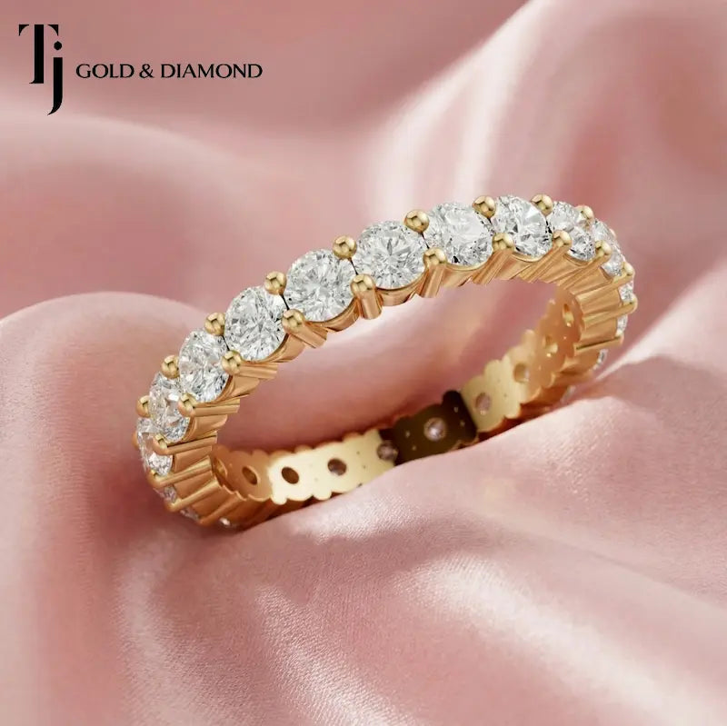 Shared prong setting full eternity diamond wedding band in 18kt yellow gold with round brilliant lab-grown diamonds.