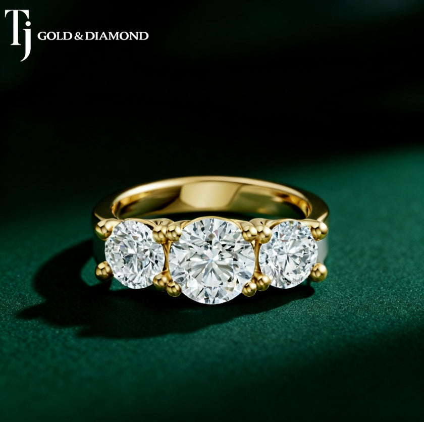 Three stone round diamond engagement ring in yellow gold featuring 3 diamonds in a classic trilogy design