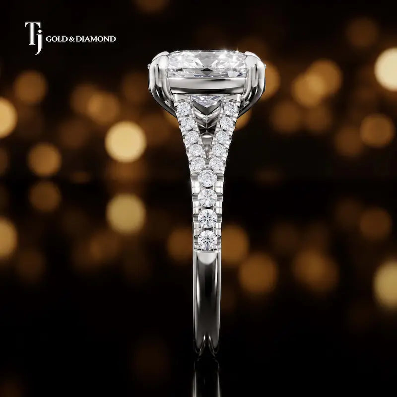 Side profile of a cushion cut split shank lab-grown diamond engagement ring with diamond-set shoulders in 18kt white gold.