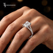 Emerald cut split shank lab-grown diamond engagement ring worn on hand in 18kt white gold.