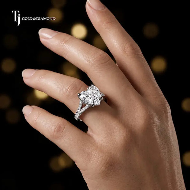 Heart cut split shank lab-grown diamond engagement ring worn on hand in 18kt white gold.