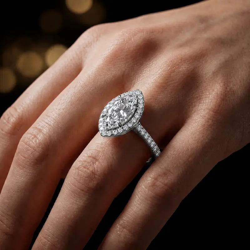 Marquise cut halo lab-grown diamond engagement ring worn on hand in 18kt white gold.