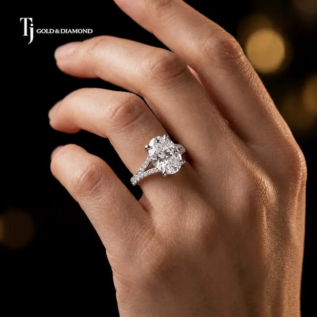 Oval cut split shank lab-grown diamond engagement ring worn on hand in 18kt white gold.