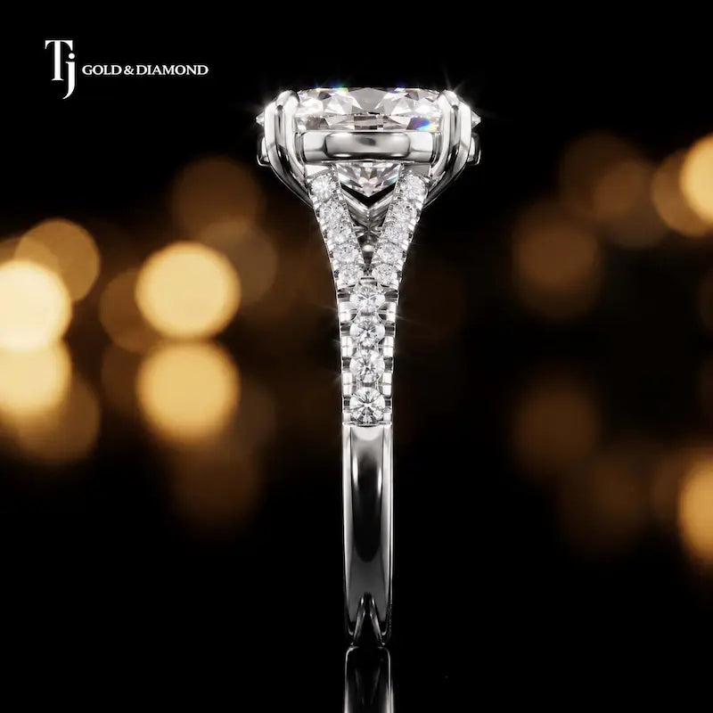 Side profile of an oval cut split shank lab-grown diamond engagement ring with diamond-set shoulders in 18kt white gold.