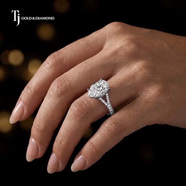 Pear cut split shank lab-grown diamond engagement ring worn on hand in 18kt white gold.
