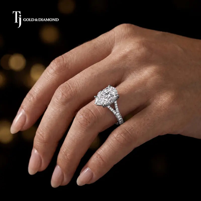 Pear cut split shank lab-grown diamond engagement ring worn on hand in 18kt white gold.