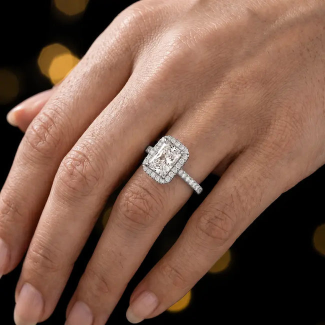 Radiant cut halo lab-grown diamond engagement ring worn on hand in 18kt white gold.