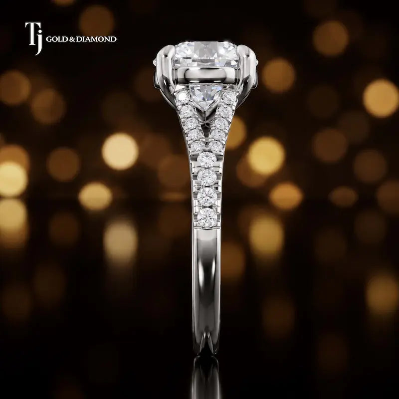 Side profile of a round cut split shank lab-grown diamond engagement ring with diamond-set shoulders in 18kt white gold.