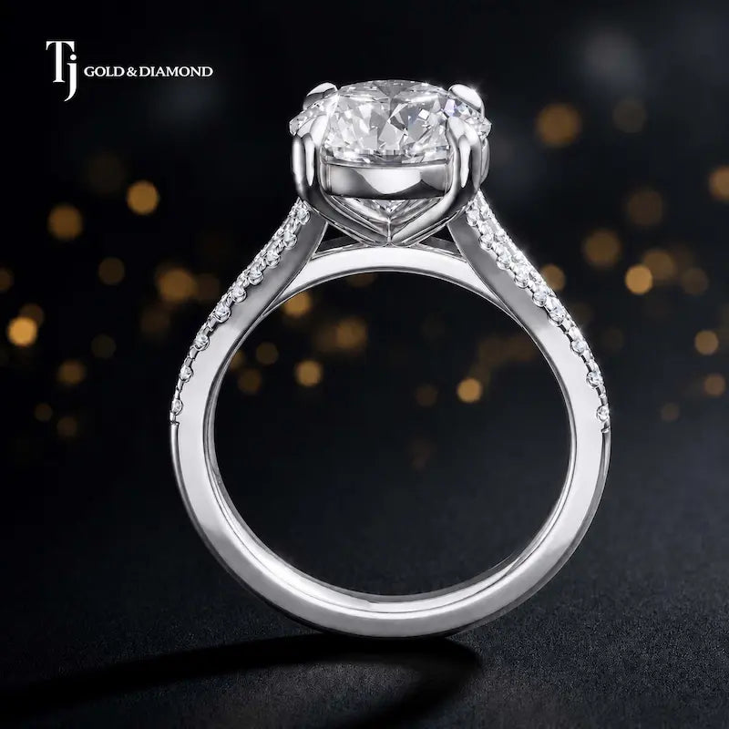 Side view of a round cut split shank lab-grown diamond engagement ring featuring a four-claw cathedral setting in 18kt white gold.