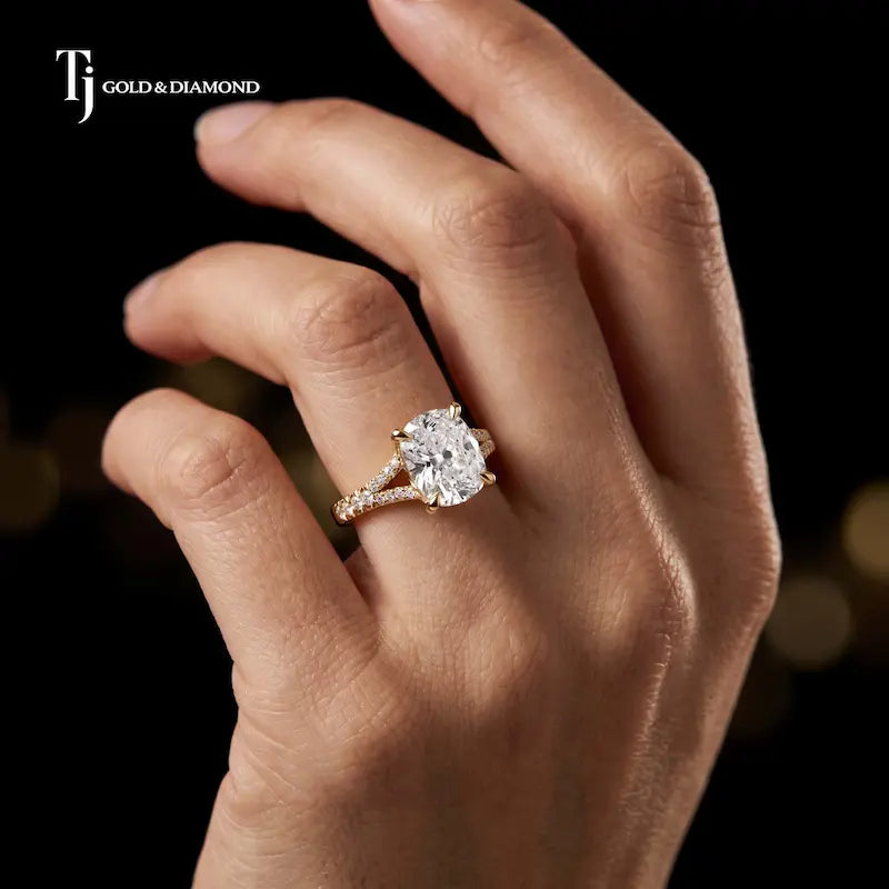 Cushion cut split shank lab-grown diamond engagement ring worn on hand in 18kt yellow gold.
