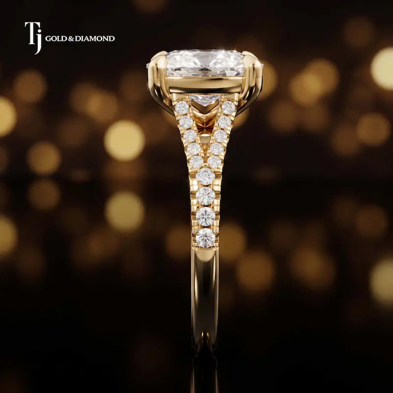 Side profile of a cushion cut split shank lab-grown diamond engagement ring with diamond-set shoulders in 18kt yellow gold.