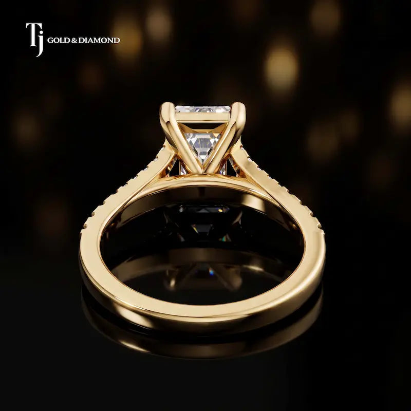 Back view of an emerald cut split shank lab-grown diamond engagement ring in 18kt yellow gold.
