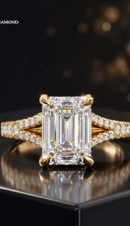 Front view of an emerald cut split shank lab-grown diamond engagement ring in 18kt yellow gold.