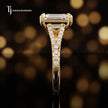 Side profile of an emerald cut split shank lab-grown diamond engagement ring with diamond-set shoulders in 18kt yellow gold.