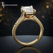 Side view of an emerald cut split shank lab-grown diamond engagement ring featuring a four-claw cathedral setting in 18kt yellow gold.