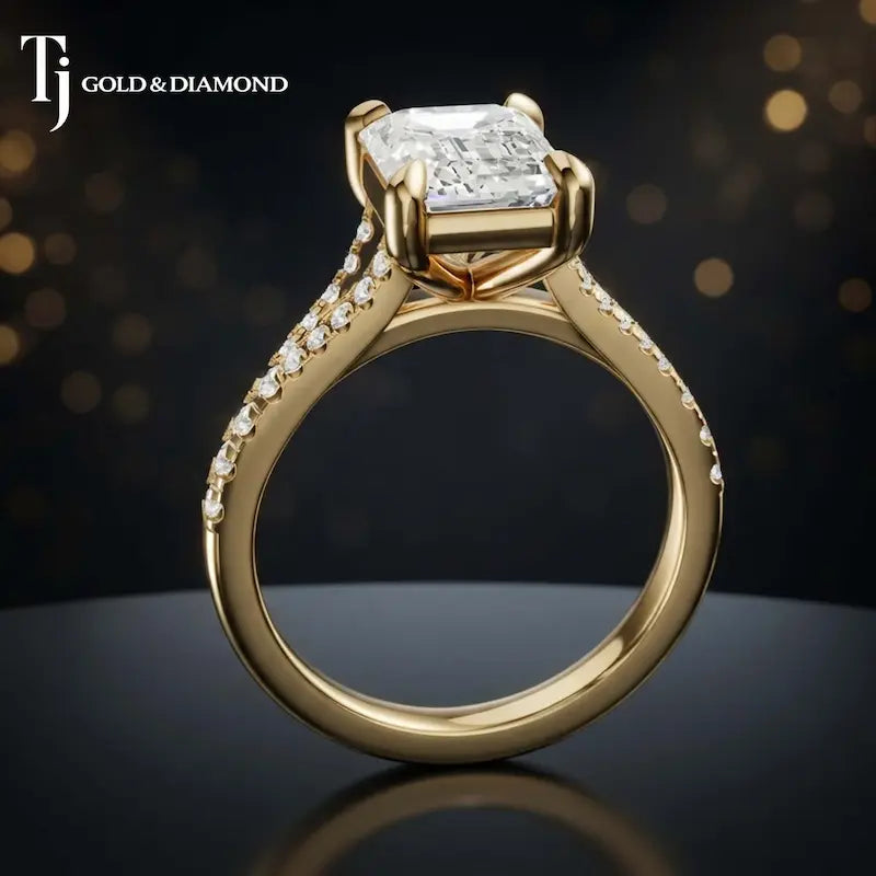 Side view of an emerald cut split shank lab-grown diamond engagement ring featuring a four-claw cathedral setting in 18kt yellow gold.