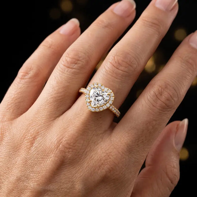 Heart cut halo lab-grown diamond engagement ring worn on hand in 18kt yellow gold.