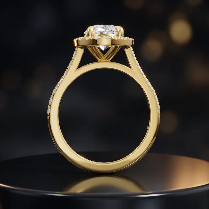 Side view of an oval cut halo lab-grown diamond engagement ring with diamond-set shoulders in 18kt yellow gold.