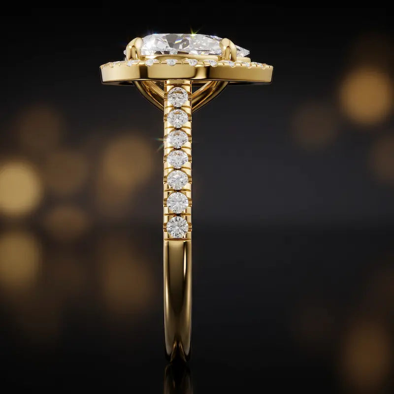 Side profile of a pear cut halo lab-grown diamond engagement ring in 18kt yellow gold.