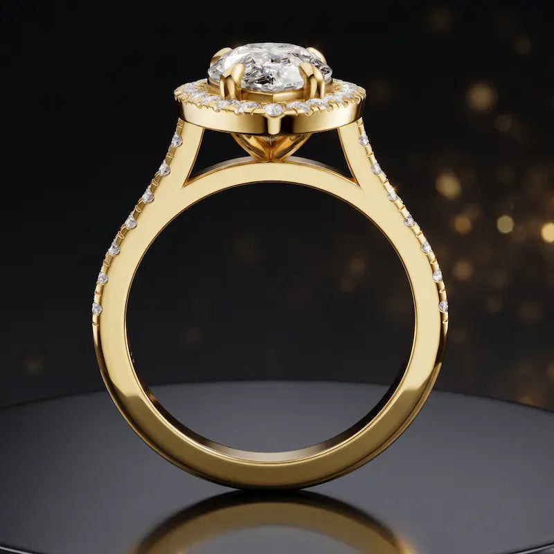 Side view of a pear cut halo lab-grown diamond engagement ring with diamond-set shoulders in 18kt yellow gold.