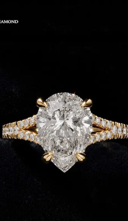 Front view of a pear cut split shank lab-grown diamond engagement ring in 18kt yellow gold.