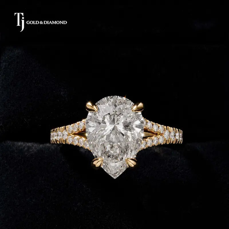 Front view of a pear cut split shank lab-grown diamond engagement ring in 18kt yellow gold.