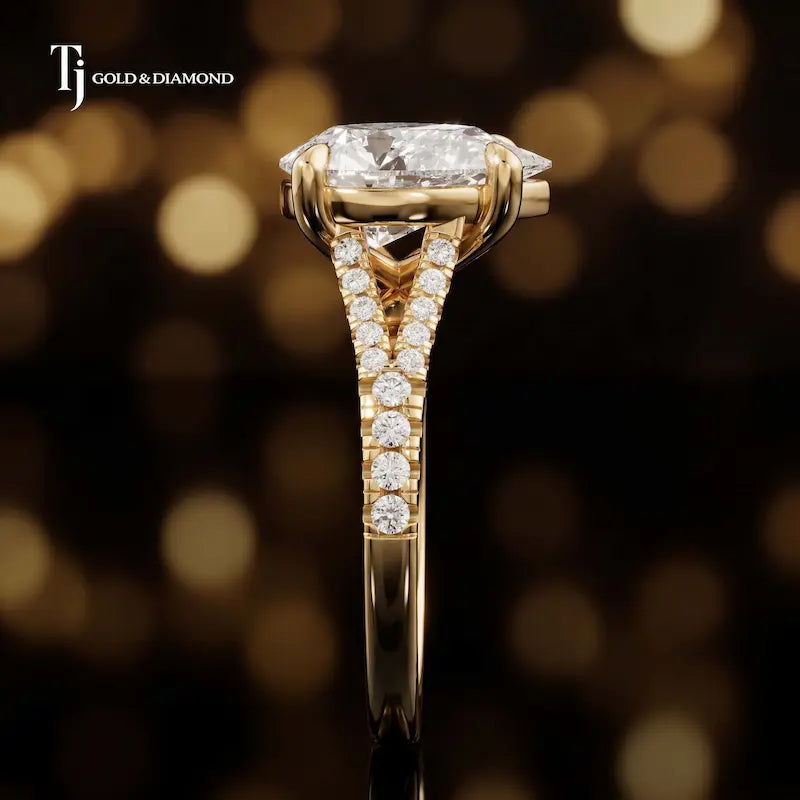 Side profile of a pear cut split shank lab-grown diamond engagement ring with diamond-set shoulders in 18kt yellow gold.