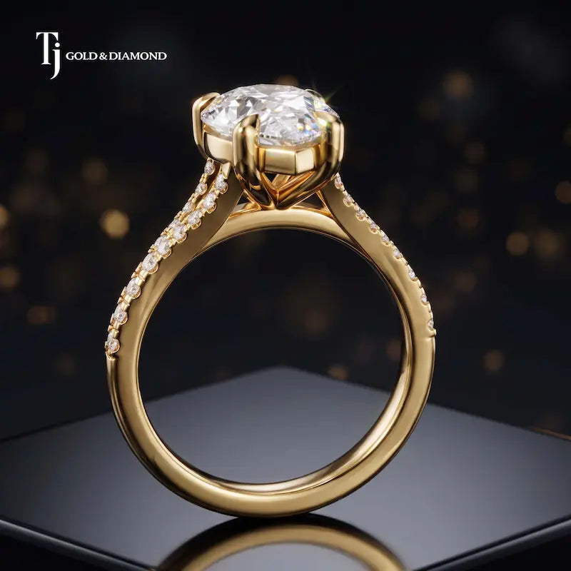 Side view of a pear cut split shank lab-grown diamond engagement ring featuring a four-claw cathedral setting in 18kt yellow gold.