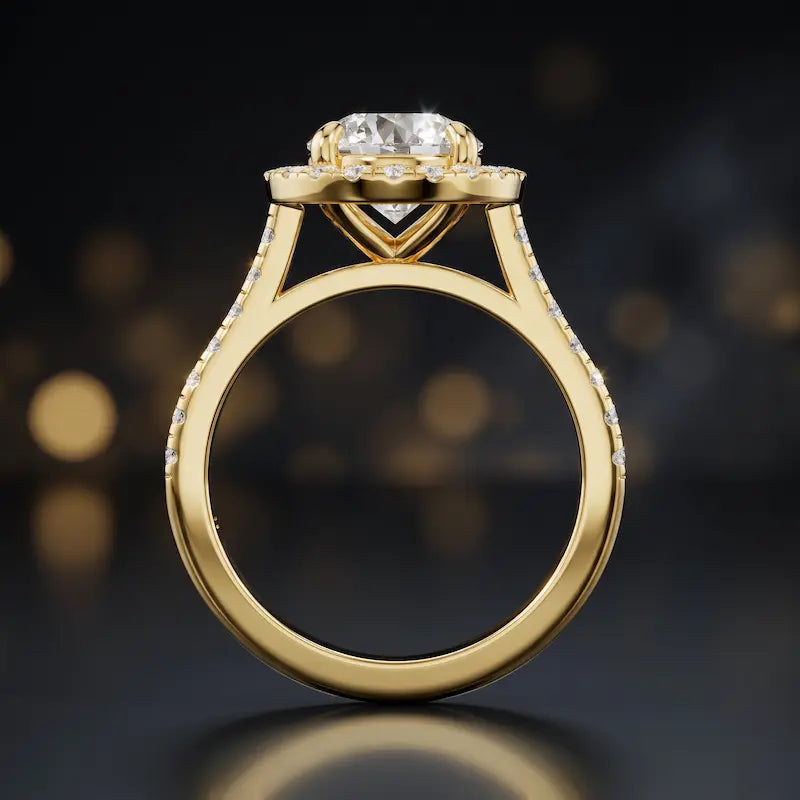 Side view of a round cut halo lab-grown diamond engagement ring with diamond-set shoulders in 18kt yellow gold.