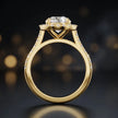 Side view of a round cut halo lab-grown diamond engagement ring with diamond-set shoulders in 18kt yellow gold.