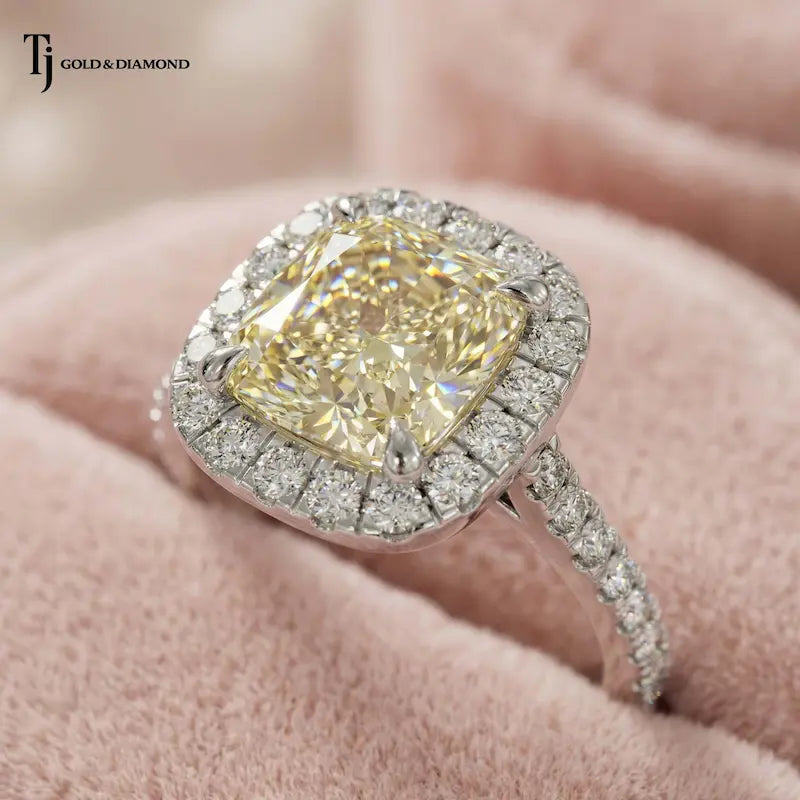 Close-up of a Cushion Cut Fancy Yellow Lab-Grown Diamond Halo Ring in 18kt white gold highlighting the cushion cut fancy yellow centre diamond and brilliant diamond halo.