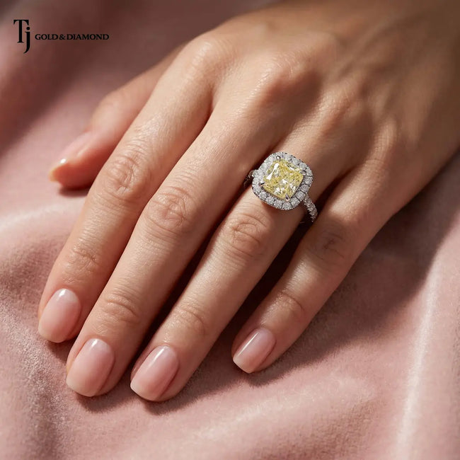 Cushion Cut Fancy Yellow Lab-Grown Diamond Halo Ring worn on hand in 18kt white gold with a diamond halo and pavé band.
