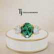 360° product view of an oval lab-created emerald trilogy engagement ring in 18kt yellow gold with oval lab-grown diamond side stones and a classic four claw basket setting.