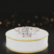 360-degree rotating view of a cushion cut three-stone diamond engagement ring in 18kt rose gold with diamond shoulders.