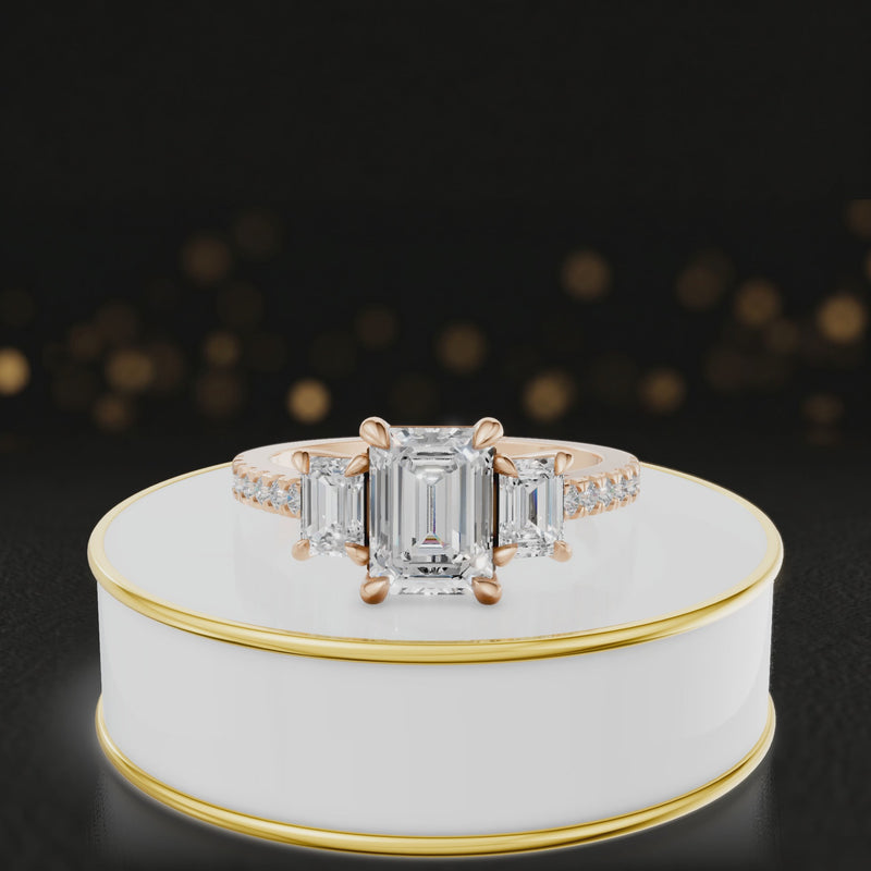360-degree rotating view of an emerald cut three-stone lab-grown diamond engagement ring in 18kt rose gold with diamond shoulders