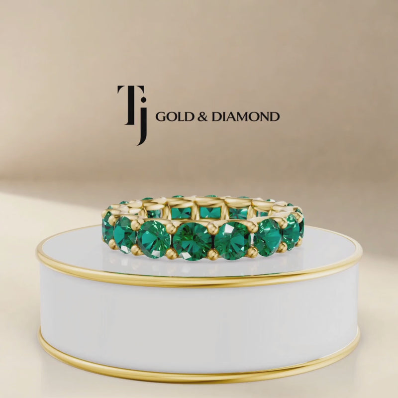 360° product view of a created emerald full eternity ring in 18kt yellow gold with round brilliant lab-created emeralds.