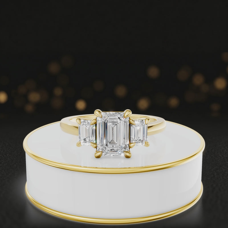 360° rotating view of an emerald-cut lab-grown diamond trilogy engagement ring in 18kt yellow gold, featuring three emerald-cut lab-grown diamonds.