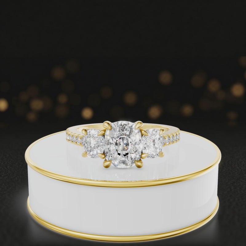 360-degree rotating view of a cushion cut three-stone lab-grown diamond engagement ring in 18kt yellow gold with diamond shoulders.