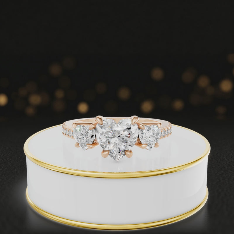 360-degree rotating view of a heart cut three-stone lab-grown diamond engagement ring in 18kt rose gold with diamond shoulders