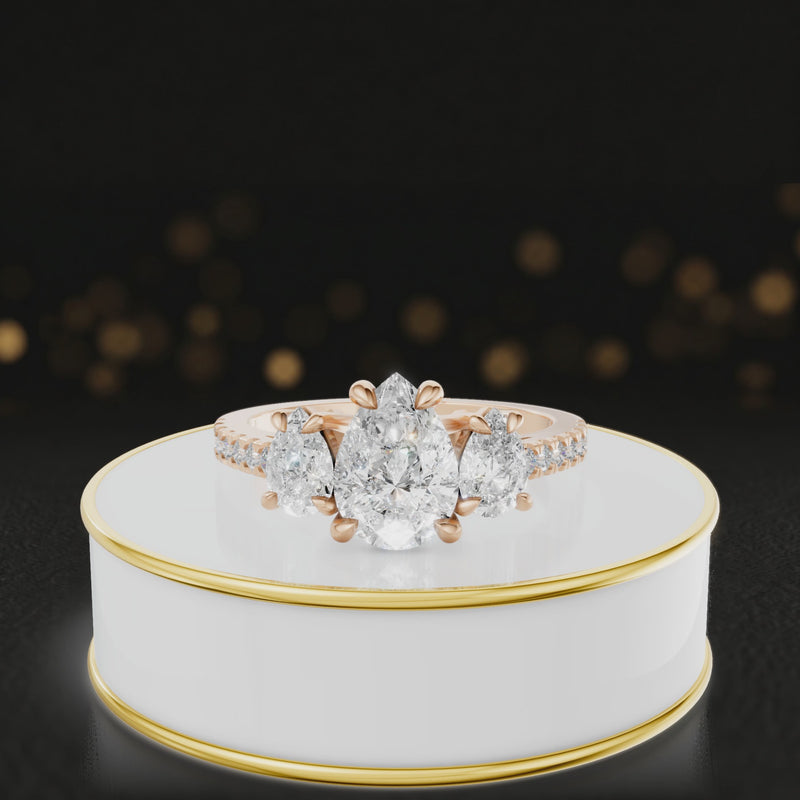 360-degree spinning view of a pear cut three-stone lab-grown diamond engagement ring in 18kt rose gold with diamond shoulders
