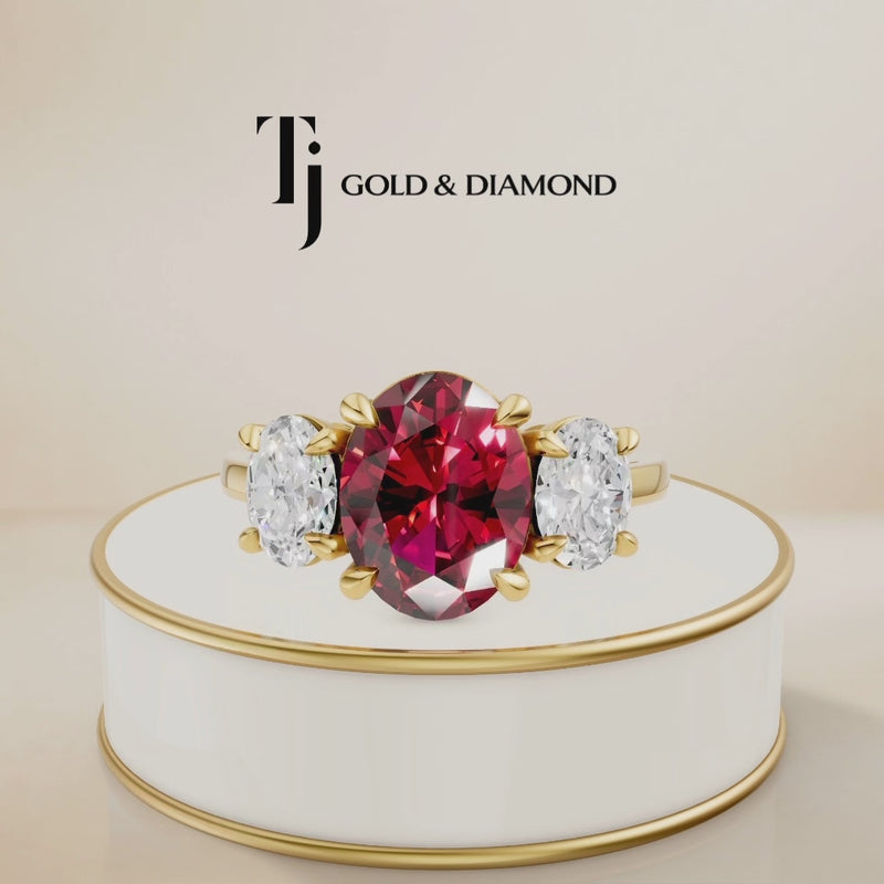 360° product view of an oval cut lab-created ruby trilogy engagement ring in 18kt yellow gold with oval lab-grown diamond side stones and a classic four claw basket setting.
