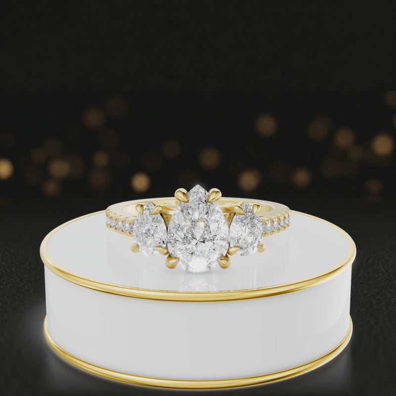 360-degree spinning view of a pear cut three-stone lab-grown diamond engagement ring in 18kt yellow gold with diamond shoulders